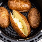 Crispy golden Air Fryer Baked Potato with fluffy interior, seasoned with salt and pepper, served fresh from the air fryer.