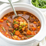 Bowl of Crockpot Vegetable Beef Soup with tender beef, potatoes, carrots, green beans, and rich broth