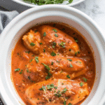 Slow cooker creamy tomato basil chicken breast served with fresh basil and grated Parmesan on top.