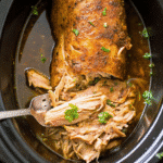 Slow Cooker Pork Loin Roast served on a platter with herbs, perfectly cooked and juicy.