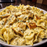 Creamy Cheesy Garlic Chicken Tortellini with golden seared chicken and Parmesan sauce in a skillet.
