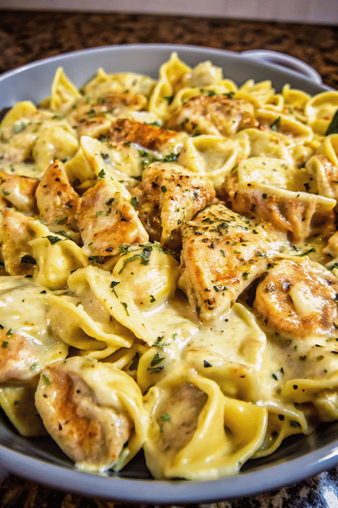 Close-up of Cheesy Garlic Chicken Tortellini coated in garlic cream sauce with grated Parmesan on top.