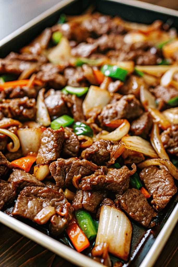 Roasted Korean-style beef bulgogi on a sheet pan with fresh vegetables and scallions.