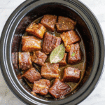Tender beef short ribs cooked in a crock pot, served with rich savory gravy over a bed of mashed potatoes.