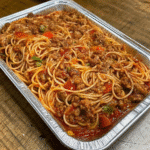 Plate of Old Fashioned Spaghetti topped with rich meat sauce, grated Parmesan cheese, and fresh parsley