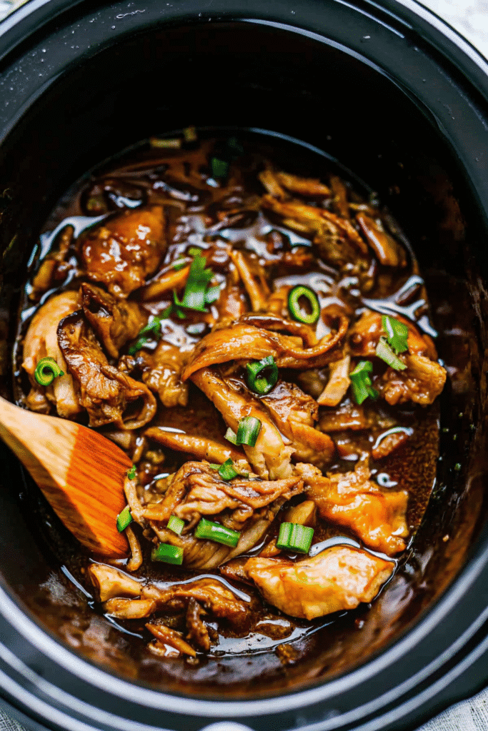 Slow cooker chicken thighs coated in a thick bourbon sauce with a golden-brown finish.