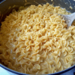 Bowl of homestyle creamy buttered noodles garnished with fresh parsley and coated in a rich, silky sauce.
