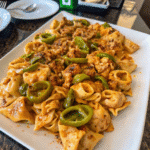 Spicy Southwest Ranch Chicken Tortellini Skillet with sliced chicken, cheese tortellini, bell peppers, and creamy ranch sauce in a cast iron pan.