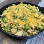Cheesy Chicken Broccoli Rice Skillet with tender chicken, fluffy rice, broccoli florets, and melted cheddar cheese in a large pan