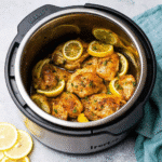 Golden-brown CrockPot Lemon Garlic Chicken served with lemon slices and parsley garnish