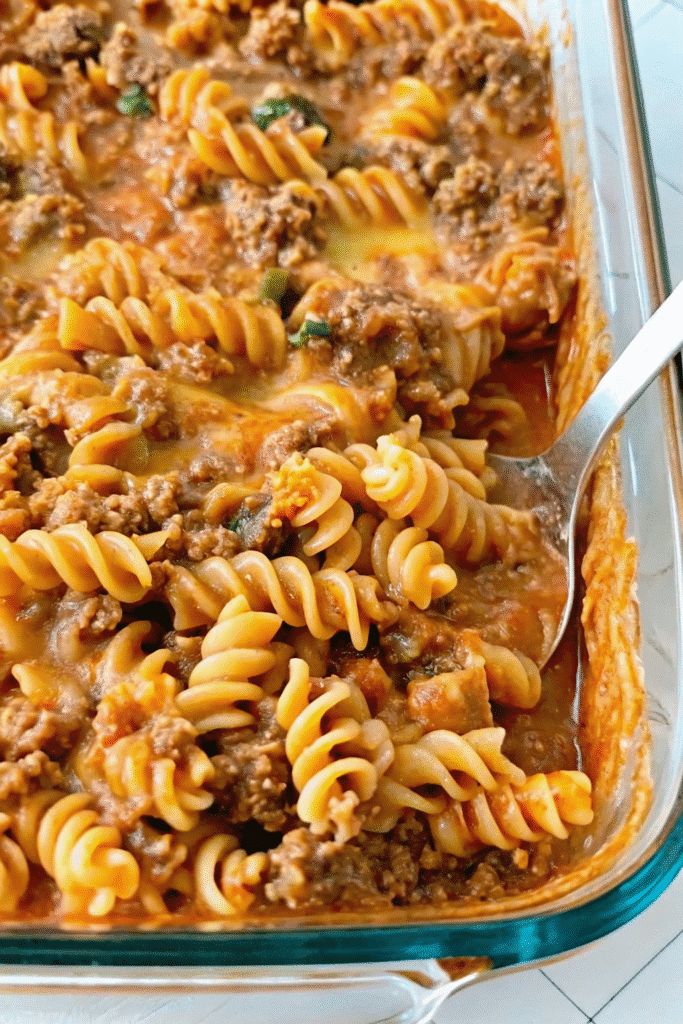 Close-up of Amish Country Casserole showing cheesy pasta, seasoned ground beef, and creamy sauce in a baked dish
