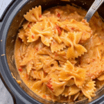 Crockpot Chicken Pasta with shredded chicken, bowtie pasta, creamy Alfredo marinara sauce, and melted mozzarella cheese