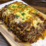 Crockpot French Onion Meatloaf topped with caramelized onions and melted Swiss cheese served with onion sauce.