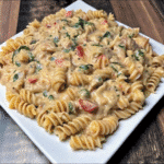 Baked Rotel Chicken Pasta topped with melted cheese and crispy Doritos in a casserole dish