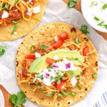 Crock Pot Chicken Tacos with shredded chicken, salsa, and fresh toppings in soft tortillas.