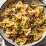 Garlic Butter Bowtie Pasta with Ground Beef served in a bowl, topped with Parmesan and fresh parsley
