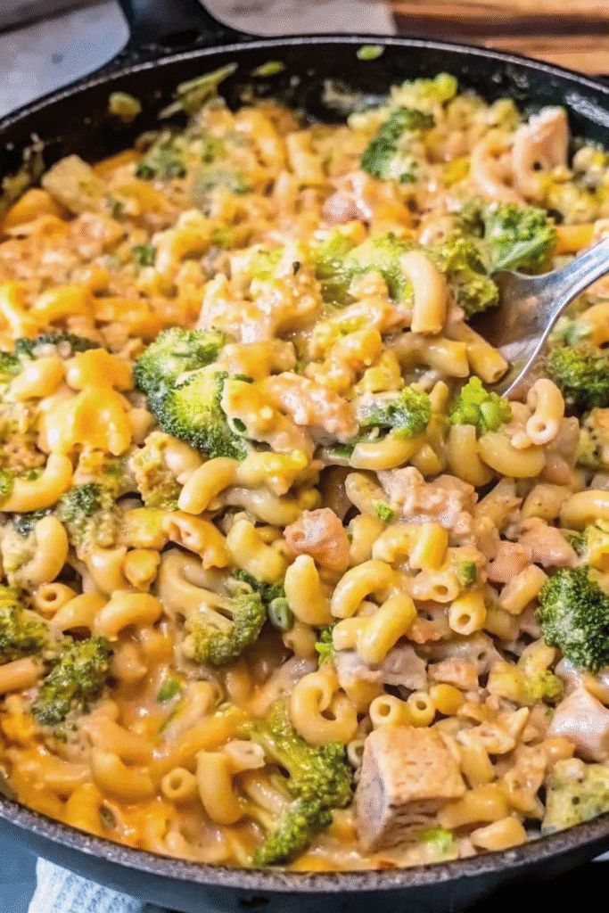 One-pan Cheesy Chicken Broccoli Mac topped with melted cheese and parsley, featuring pasta, seasoned chicken, and fresh broccoli.
