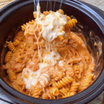 Creamy Crockpot Chicken Pasta served in a bowl with shredded chicken, rotini pasta, marinara Alfredo sauce, and melted mozzarella cheese.