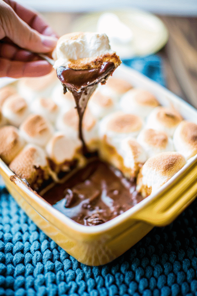 Creamy Smores Dip with melted milk chocolate, roasted marshmallows, and graham crackers on the side.