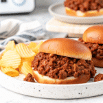 Slow cooker filled with Crock Pot Sloppy Joes, showing saucy ground beef mixture served on soft hamburger buns.