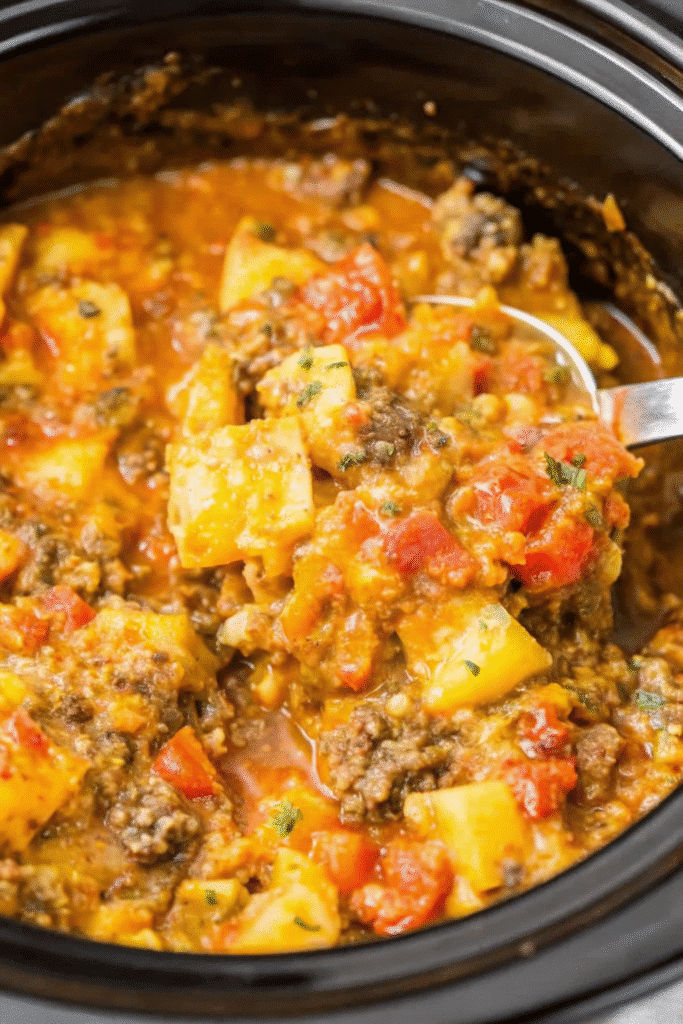 Close-up of Crockpot Cheesy Taco Potatoes with Rotel tomatoes, ground beef, and gooey melted cheese.