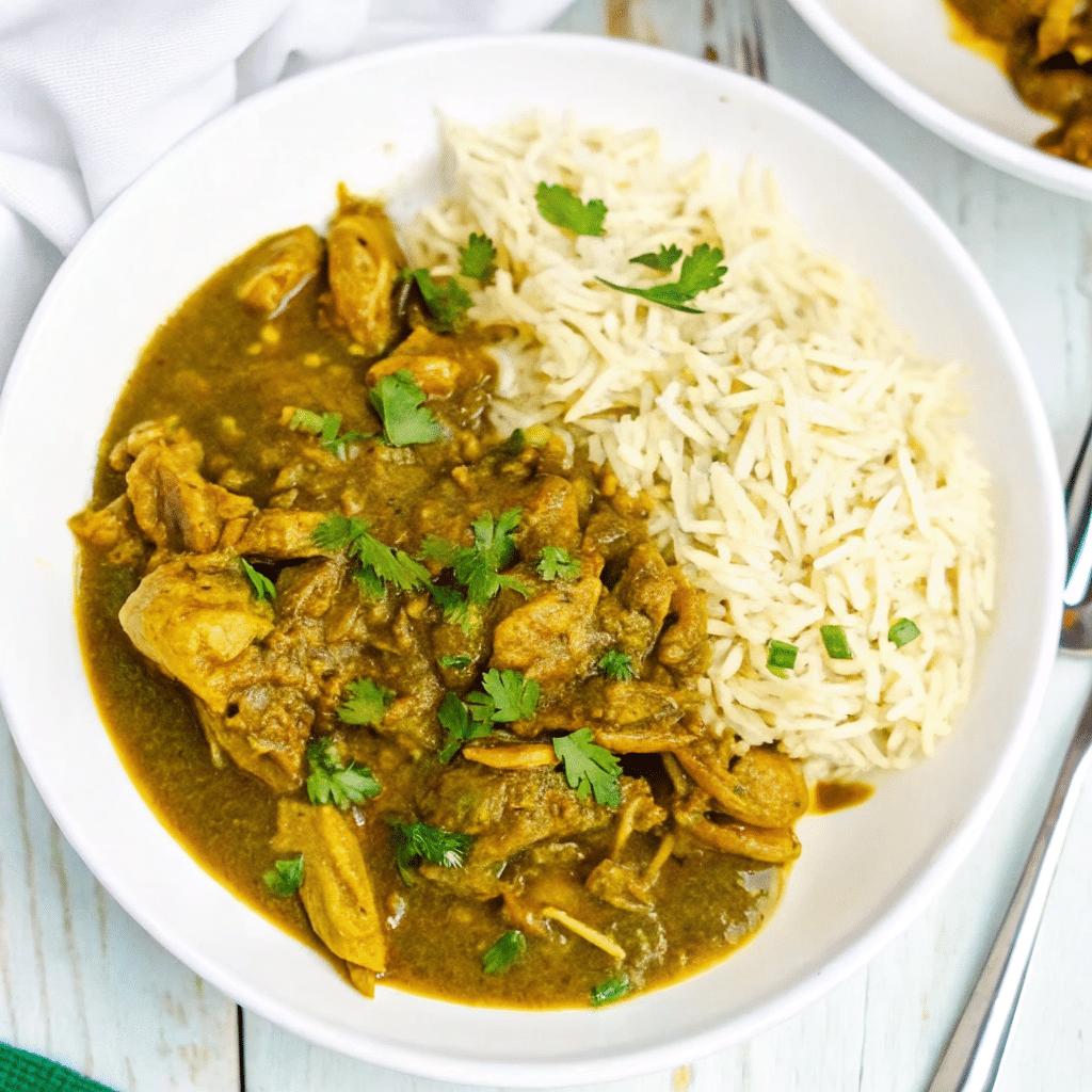 Crock Pot Chicken Curry served in a bowl with tender shredded chicken in a creamy coconut curry sauce, garnished with herbs.