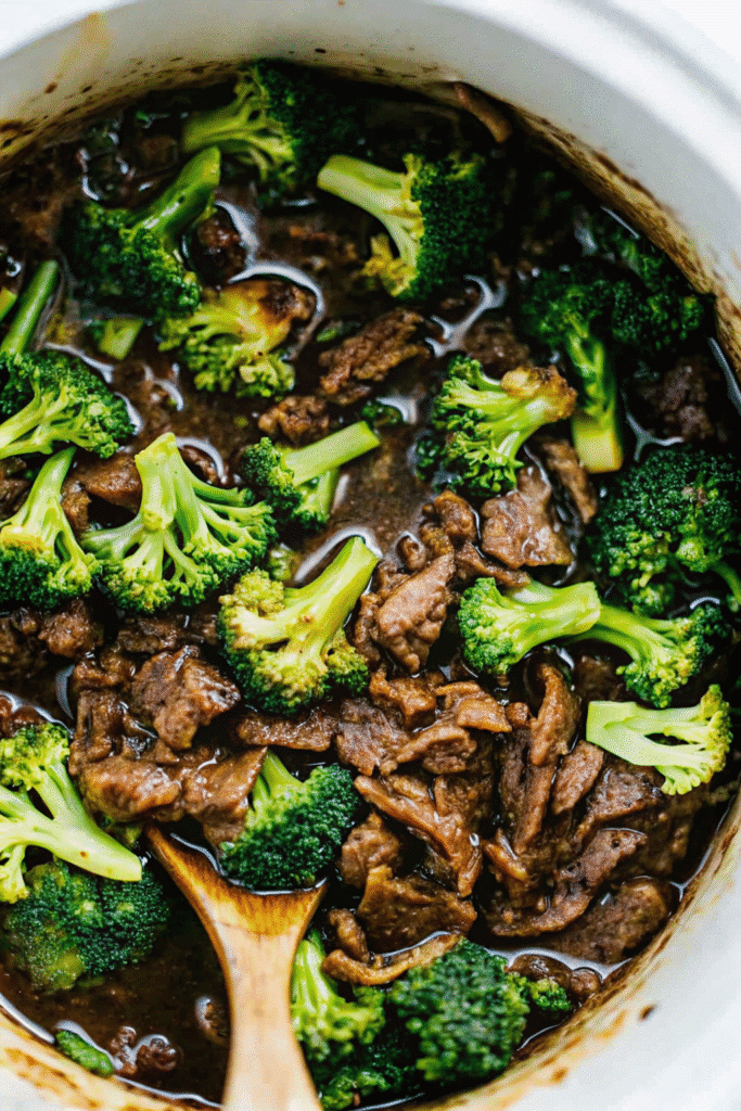 Close-up of Crock Pot Beef and Broccoli featuring juicy slow-cooked beef, broccoli florets, and glossy savory sauce in a bowl.