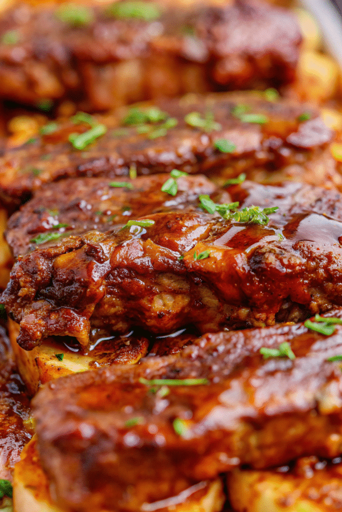 Close-up of Crock Pot Country Style Pork Ribs served with glossy BBQ glaze and soft onions from slow cooking.