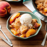 Crock Pot Peach Cobbler with soft baked peaches and golden cinnamon topping in a slow cooker.