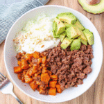 Ground Beef Bowl with seasoned beef, roasted sweet potatoes, avocado slices, and cottage cheese topped with hot honey
