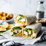 Chicken Caesar Wrap filled with crisp romaine, grilled chicken, Parmesan cheese, and creamy Caesar dressing in a soft tortilla.