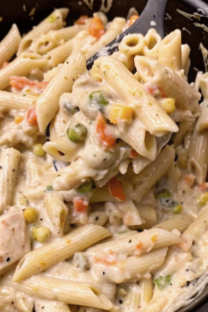 Close-up of Crockpot Chicken Pot Pie Pasta served in a bowl with shredded chicken, vegetables, and creamy herb sauce