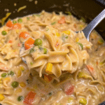 Crockpot Creamy Chicken with shredded chicken, egg noodles, and mixed vegetables in a rich creamy sauce