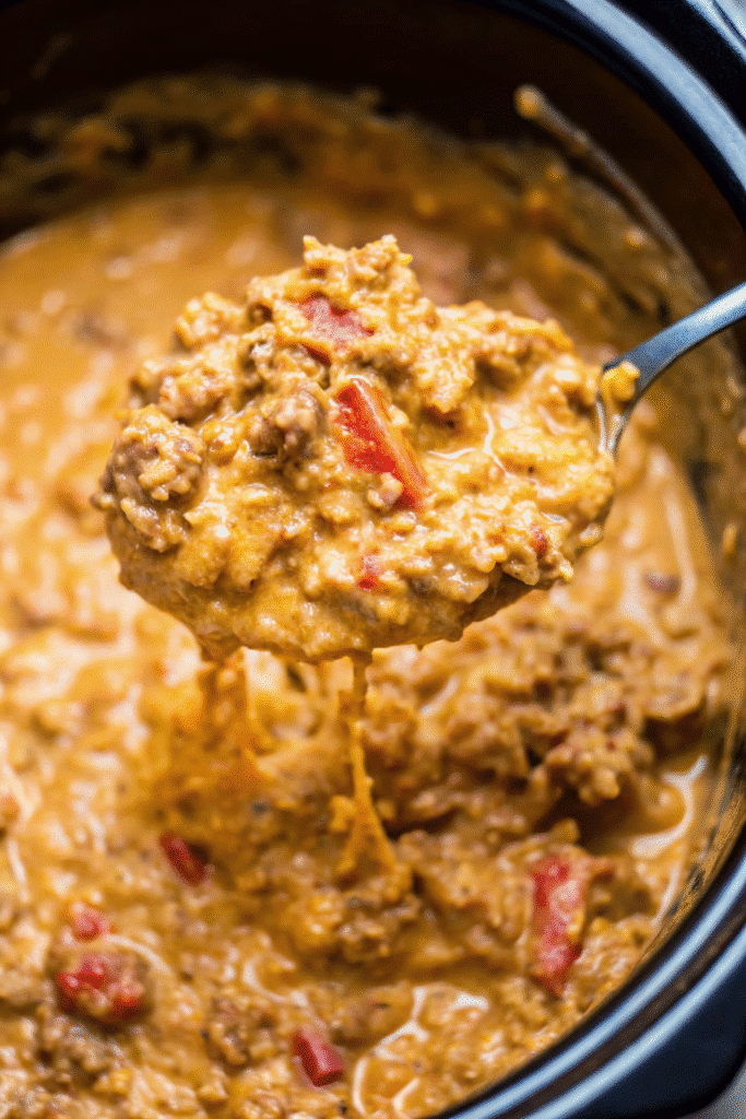 Slow cooker Crockpot Loaded Queso Beef And Rice with melted cheese, seasoned beef, and rice in a rich queso-style sauce.