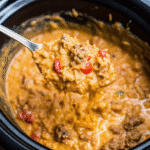 Crockpot Loaded Queso Beef And Rice served in a bowl, creamy cheesy beef and rice with melted cheddar and ground beef.