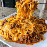 Creamy Garlic Butter Beef Spaghetti topped with Parmesan cheese and fresh parsley in a serving bowl.