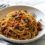 Dirty Spaghetti with ground beef, turkey sausage, bell peppers, and rich Cajun tomato gravy sauce