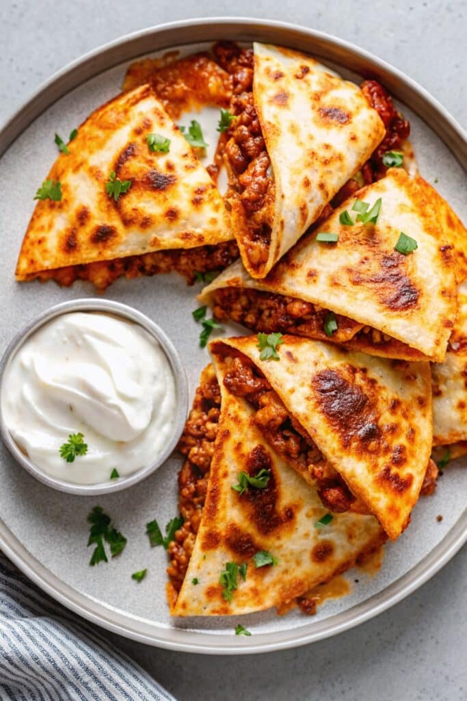 Close-up of cheesy Ground Beef Quesadillas with a golden tortilla crust, savory taco-seasoned beef filling, and melted cheese oozing out.