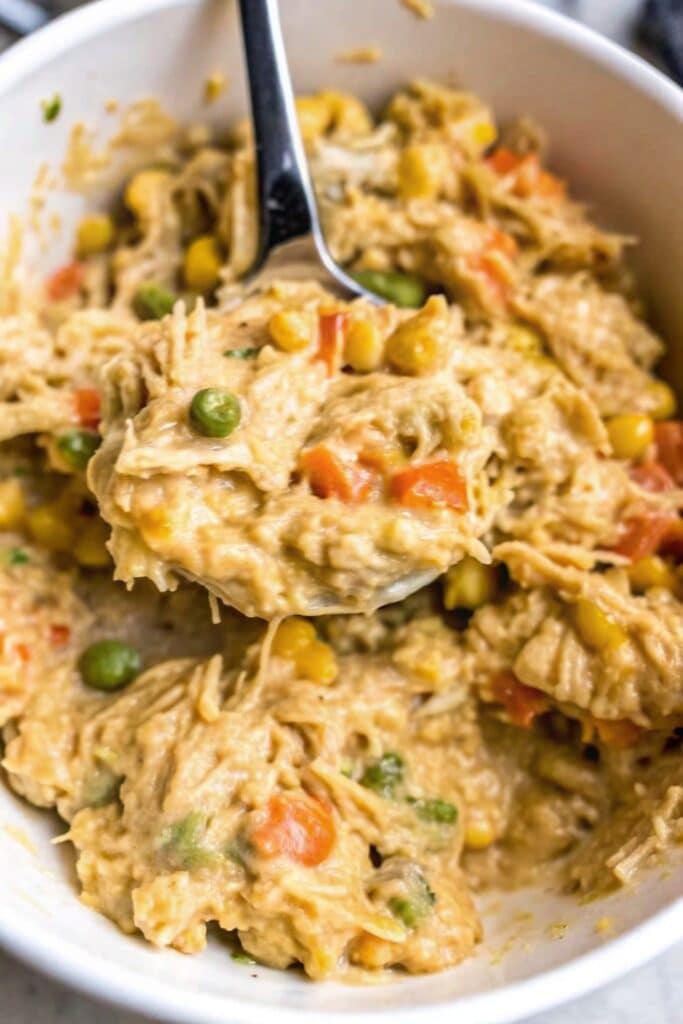 Crockpot Chicken And Stuffing Casserole 2 Homemade Crockpot Chicken And Stuffing Casserole topped with golden melted cheddar cheese in a slow cooker.