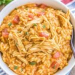 Bowl of Crockpot Taco Chicken And Rice made with shredded chicken, cheesy Mexican rice, and diced tomatoes, topped with fresh cilantro.