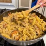 Creamy One Pan Chicken Cheddar Pasta served in a skillet with tender chicken pieces, pasta, and rich melted cheddar cheese sauce.