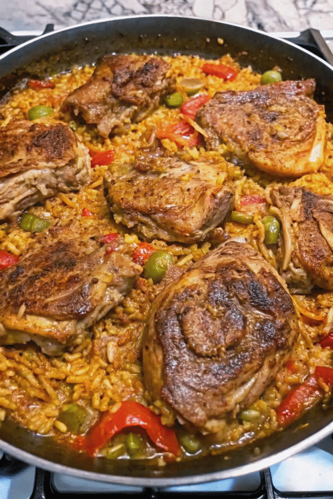 Cajun Chicken and Rice 3 Close-up of Cajun Chicken and Rice with golden chicken thighs, seasoned rice, tomatoes, peppers, and fresh herbs.
