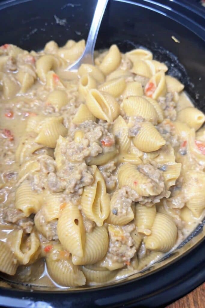 Cheesy Nacho Beef And Shell Pasta topped with seasoned beef and creamy melted cheese sauce in a serving bowl.