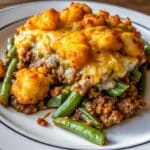 Golden Tater Tot Hamburger Green Bean Casserole baked with seasoned ground beef, green beans, melted cheddar cheese, and crispy tater tots.