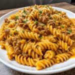 Creamy Cajun Ground Beef Rotini served in a bowl with seasoned ground beef, rotini pasta, melted cheese sauce, and fresh parsley garnish.