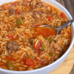 Stuffed Pepper Orzo Skillet with ground beef, bell peppers, orzo pasta, marinara sauce, and melted cheddar cheese in a cast iron skillet.